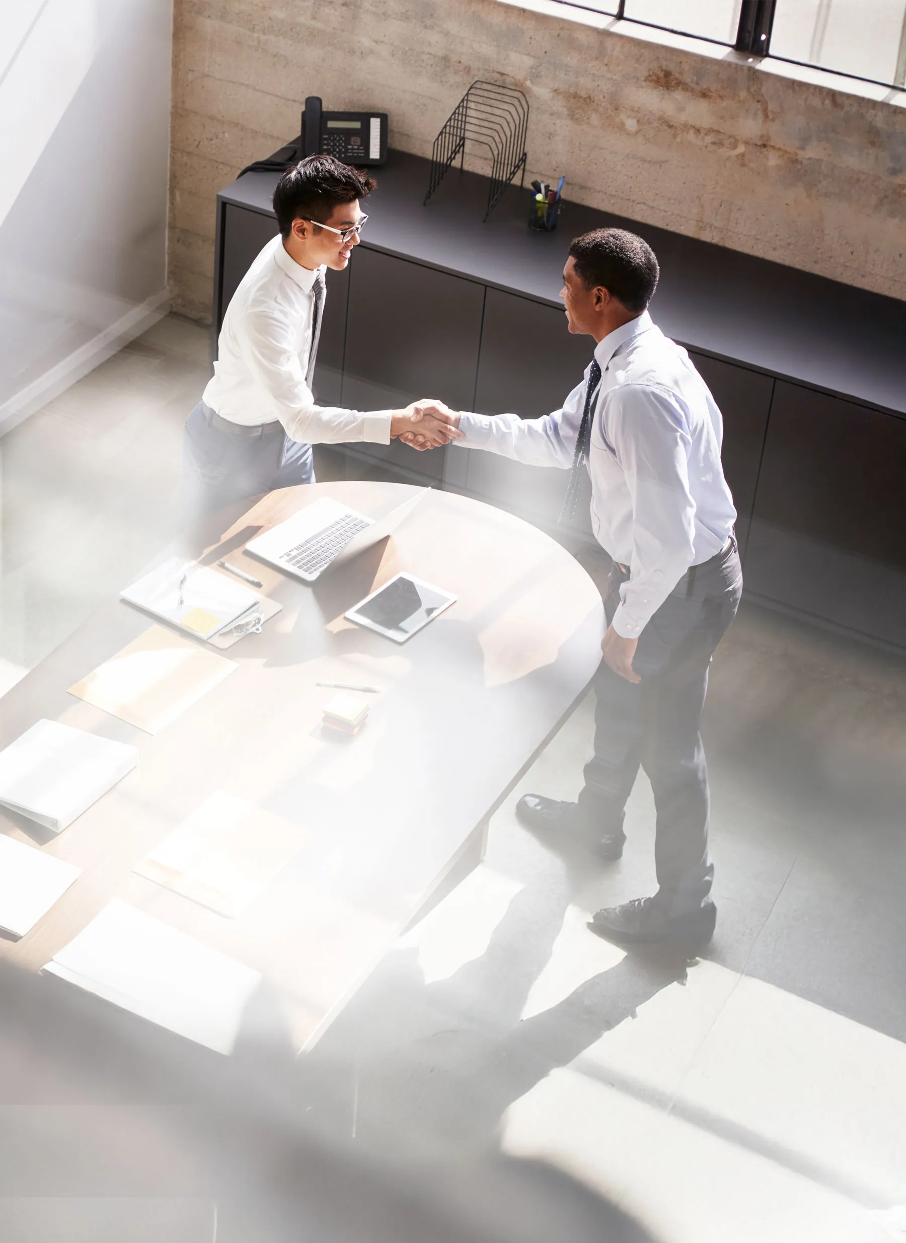 Dos hombres cerrando un trato comercial estrechando sus manos con firmeza